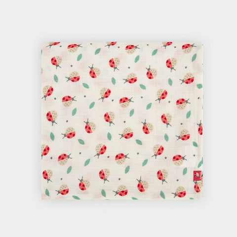 Copertina in cotone con fantasia di coccinelle colorate su sfondo bianco.