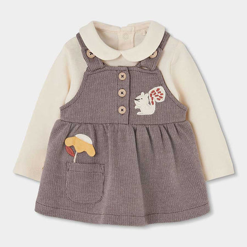 Abito salopette lilla con maglia crema a maniche lunghe e dettagli ricamati con scoiattolo e fungo