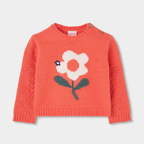 Maglione color corallo con grande fiore bianco e verde sul davanti e bottoni sulla spalla