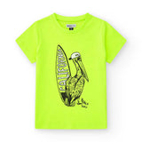 T-shirt gialla con disegno di un pellicano e scritte sulla spiaggia.