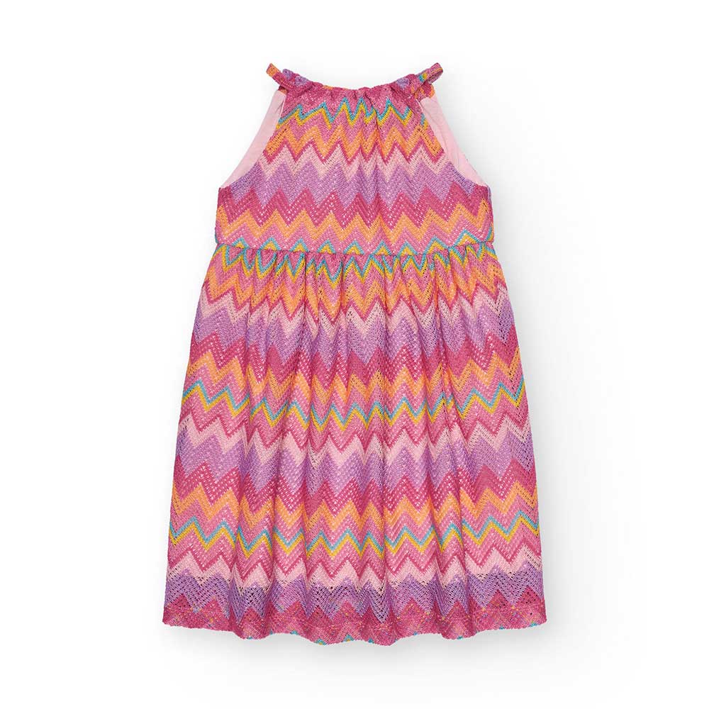 Dress from the Nath Kids Girls' Clothing Line, pleated with a colorful geometric pattern.Composti...