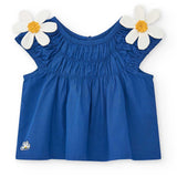 Blusa blu con arricciatura e margherite bianche sulle spalline.