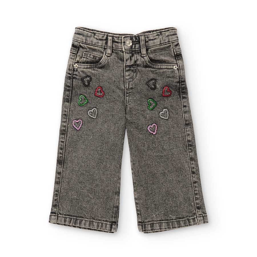 Questi pantaloni jeans con dettagli di cuori colorati sono perfetti per accompagnare la tua bambi...